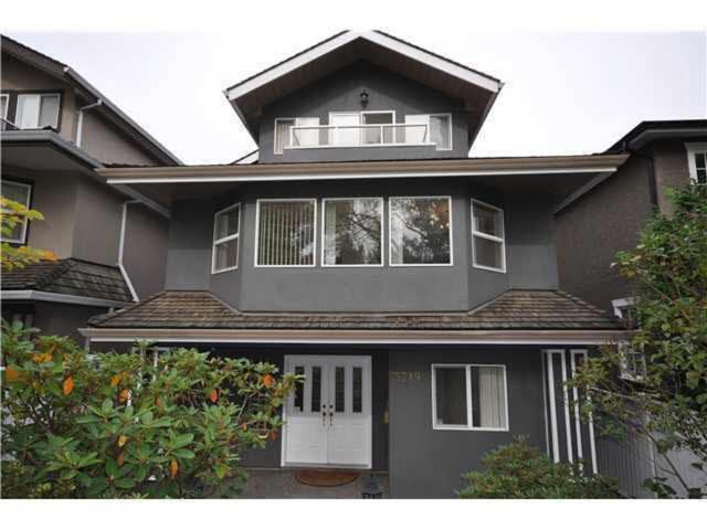 een zwart huis met een witte deur en ramen bij ALMA HOME in Vancouver