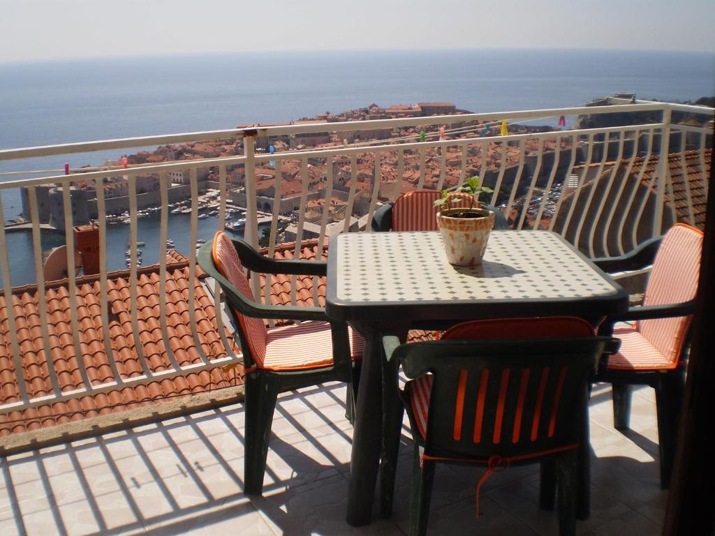 una mesa y sillas en un balcón con vistas al océano en Apartments Kuzman, en Dubrovnik