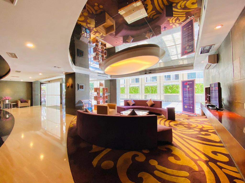 un soggiorno con divano e tavolo di Habitare Apart Hotel Rasuna Jakarta Powered by Archipelago a Giacarta