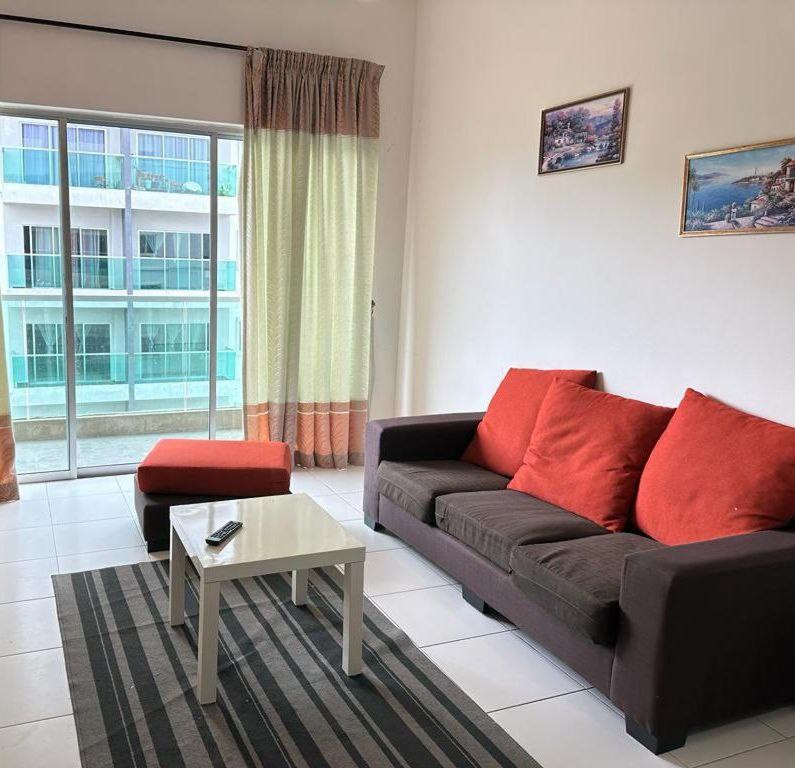 a living room with a black couch and red pillows at Family Stay at Quintet A2-7-3A in Tanah Rata