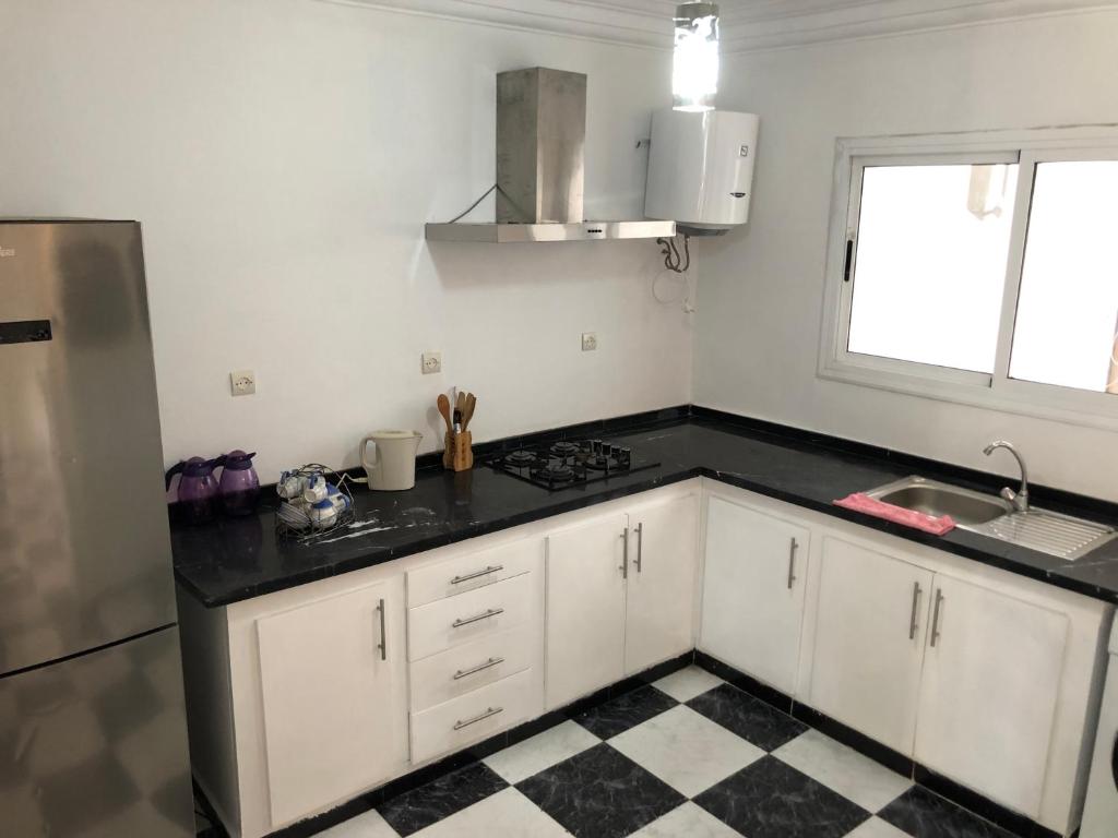 a kitchen with white cabinets and a black counter top at Casa lux in Tetouan