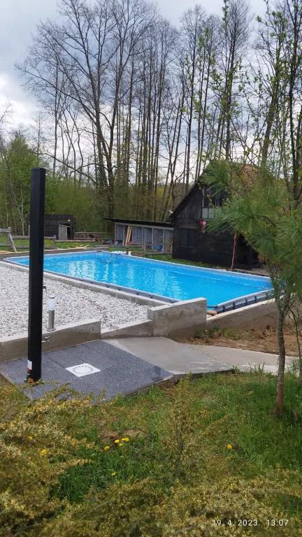 a large swimming pool with a house in the background at Kuća za odmor/Party kuća in Lukinić Senovec