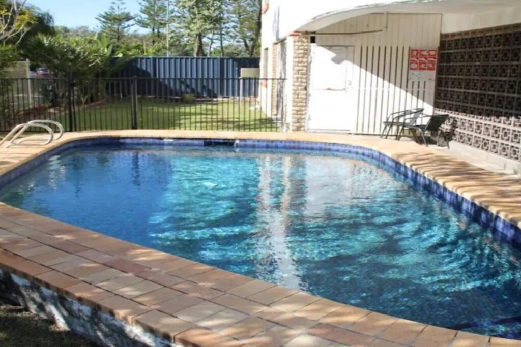 a swimming pool with blue water in a yard at Kundu Lodge - Hosted by Burleigh Letting in Gold Coast