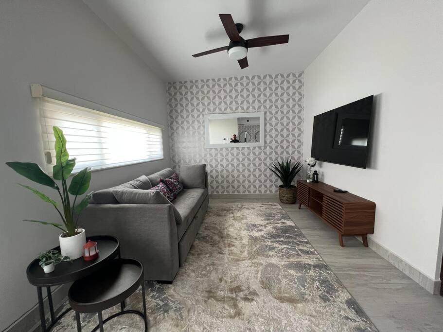 a living room with a couch and a flat screen tv at Consulado Home in Ciudad Juárez