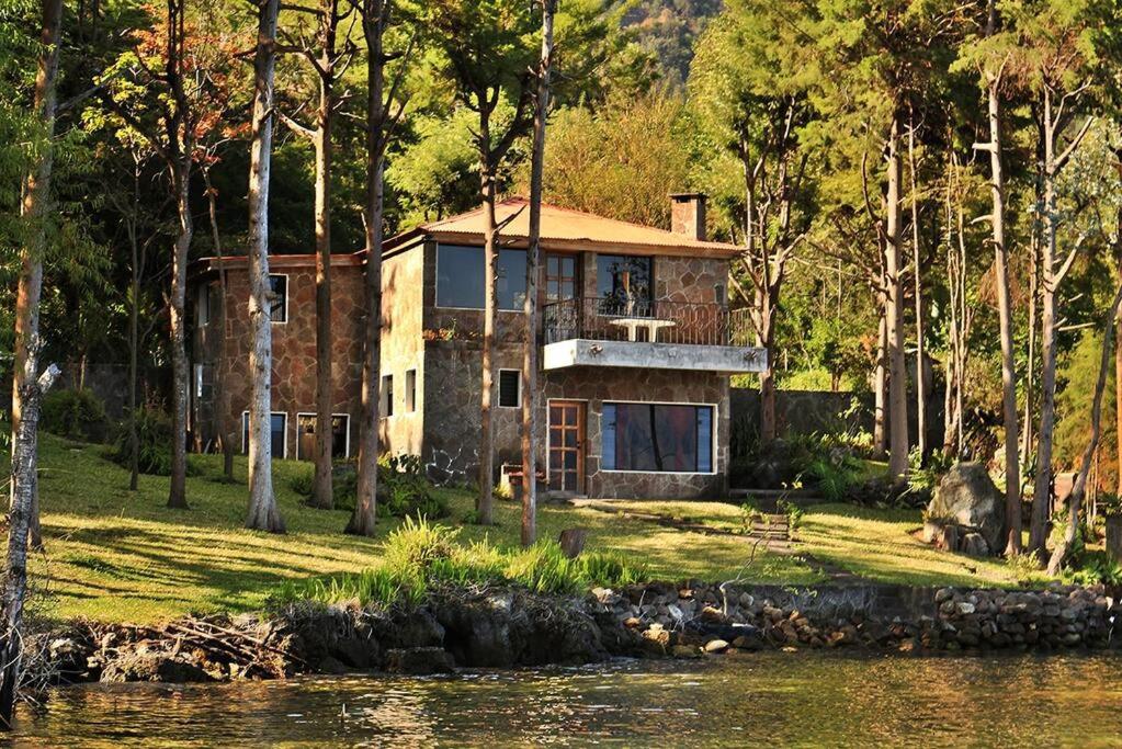 a house sitting on the side of a lake at Inlaquesh Villa Atitlán in Cerro de Oro