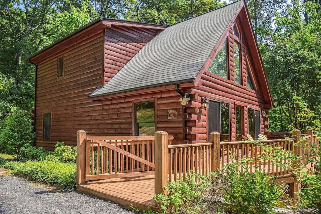 een houten hut met een houten hek ervoor bij Spectacular Log Cabin Home 45 minutes to Asheville in Marion