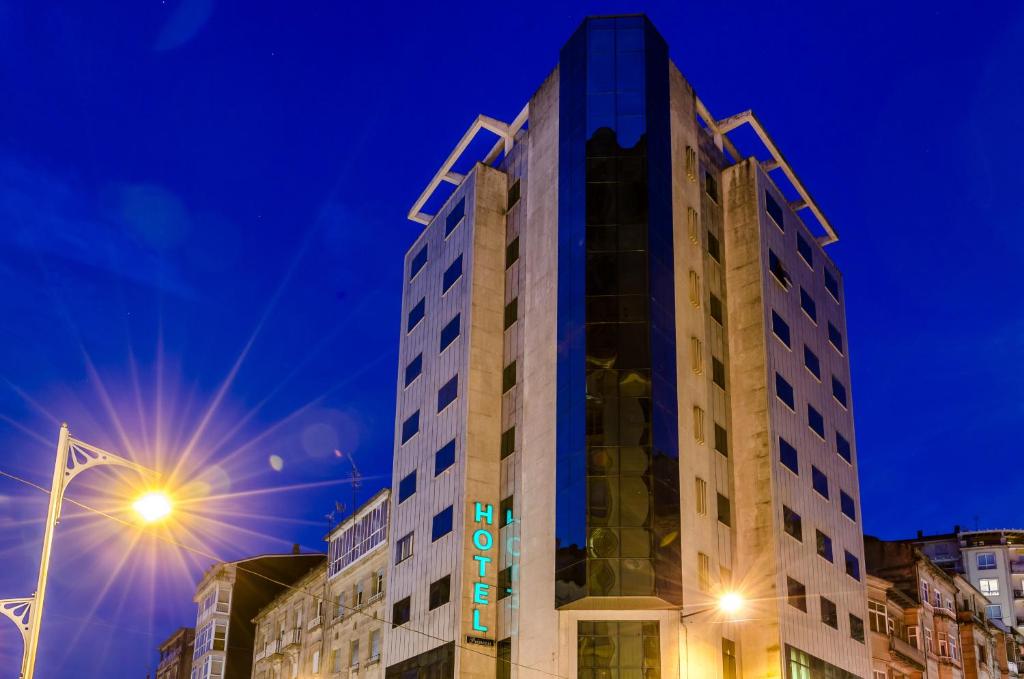 a tall building in a city at night at Hotel Princess in Ourense