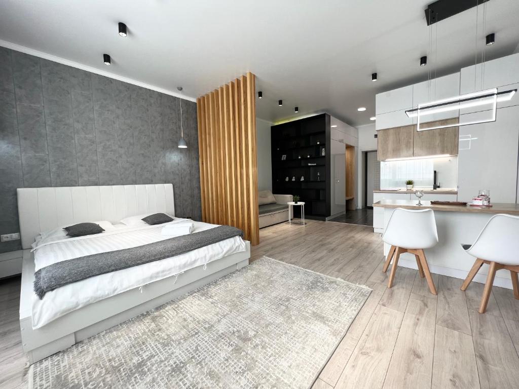1 dormitorio con 1 cama grande y cocina en VIP-апартаменты в элитной новостройке. en Pavlodar