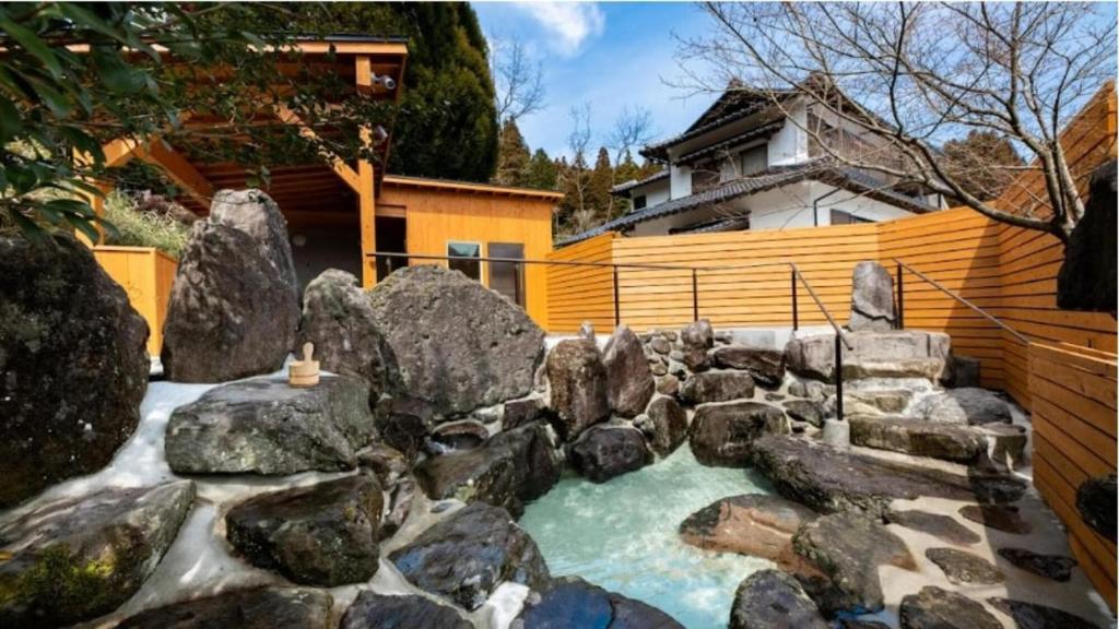 una piccola piscina d'acqua con rocce in un cortile di YUFUIN O-YADO YUKI ONSEN a Yufu