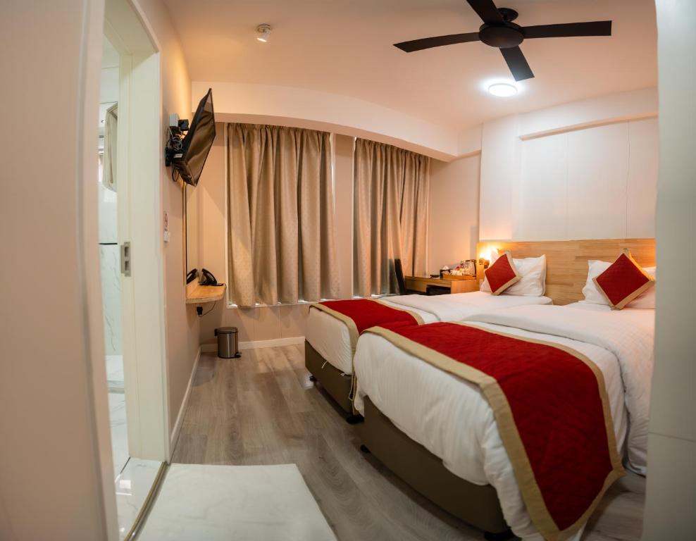 um quarto de hotel com 2 camas e uma ventoinha de tecto em Tourist Inn Grand em Malé
