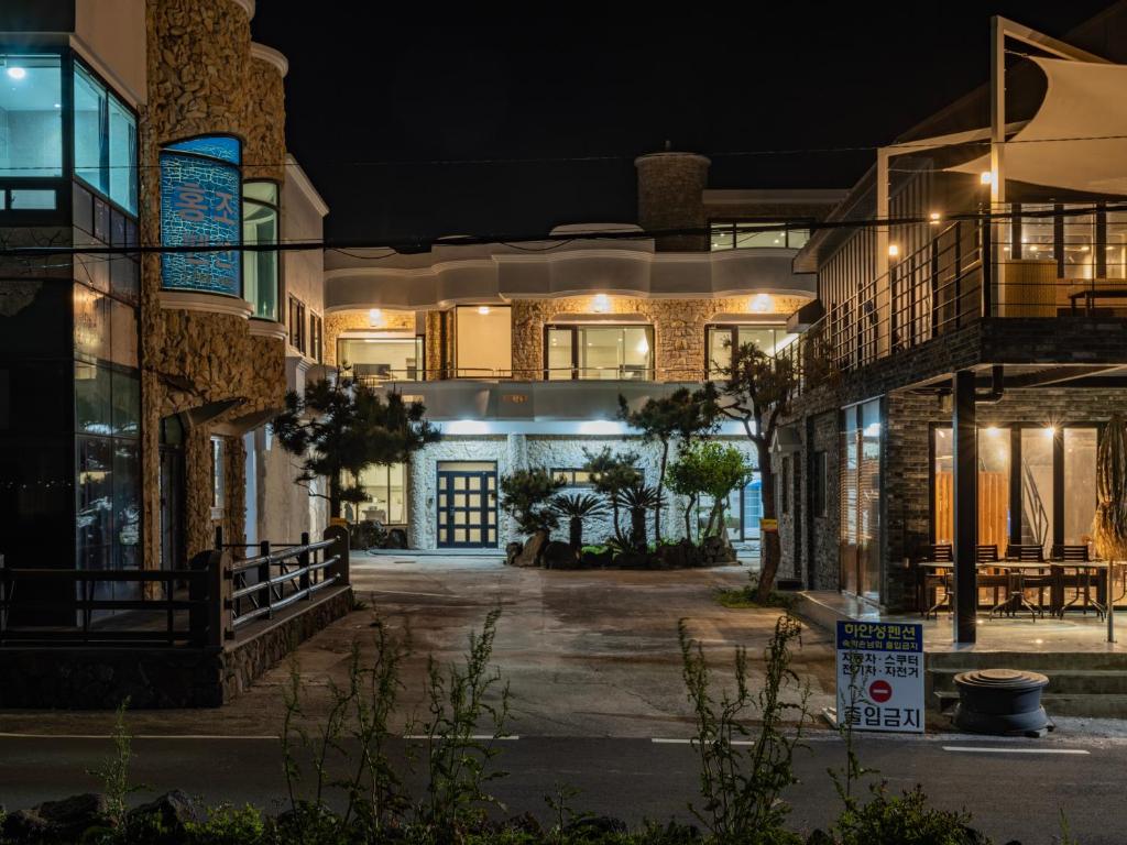 an empty street at night with a building at White Castle Pension in Jeju