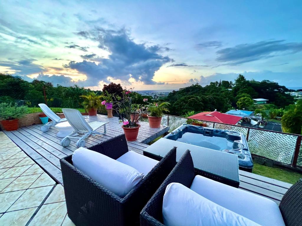 a patio with chairs and a hot tub on a deck at Papeete happiness pool and spas in Papeete