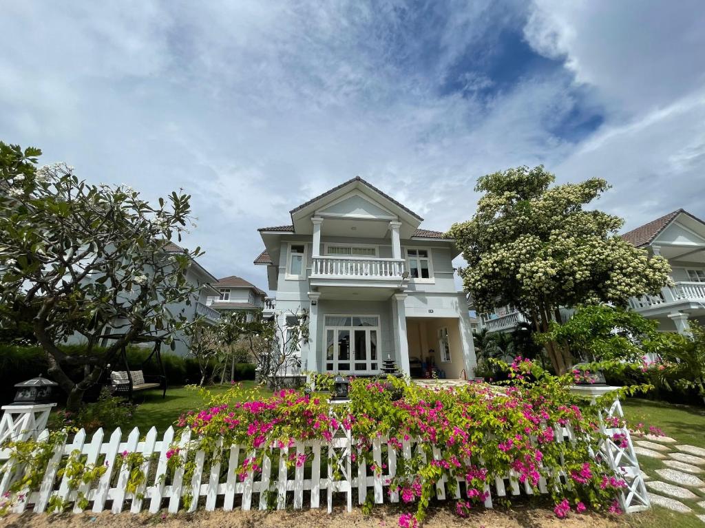 una cerca blanca frente a una casa con flores en Villa Sea View Phan Thiet Mui Ne, en Mui Ne