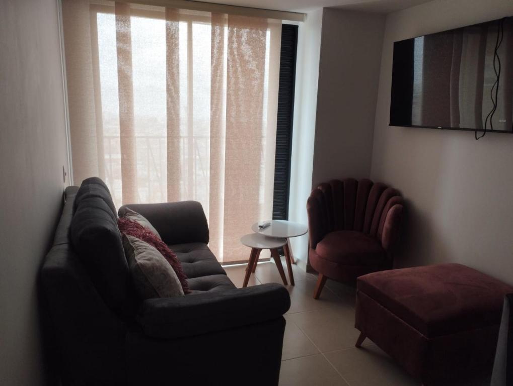 a living room with a couch and a chair and a window at APARTAMENTO EN BUCARAMANGA, ZONA CENTRICA in Bucaramanga
