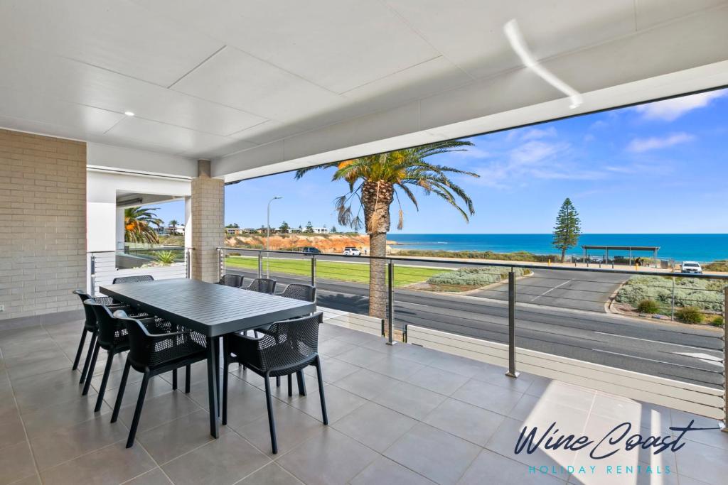 a dining room with a view of the ocean at Oceanview Escape by Wine Coast Holidays in Port Noarlunga South