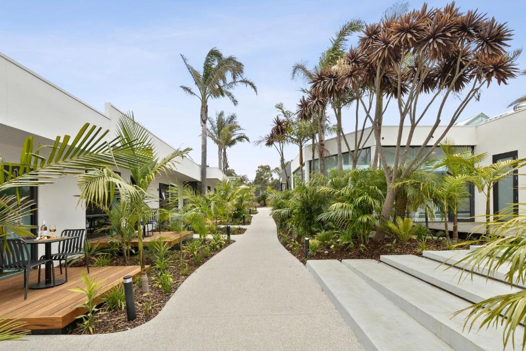 a walkway in front of a building with palm trees at Great Ocean Road Resort in Anglesea