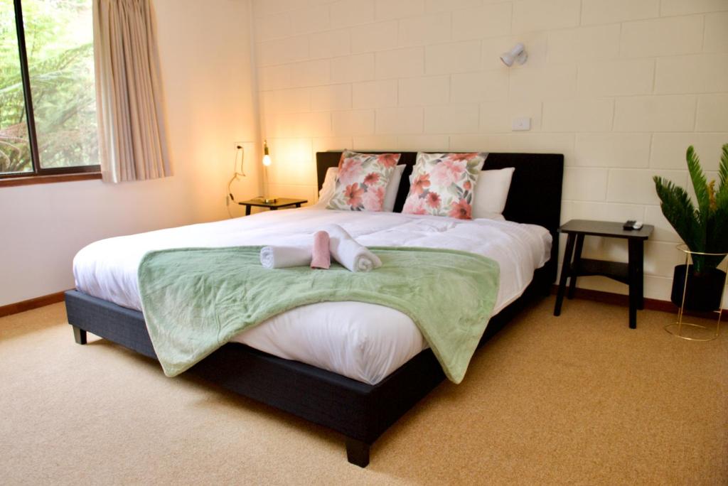 a bedroom with a large bed with two towels on it at Green Gables Warburton - King Garden Suite in Warburton