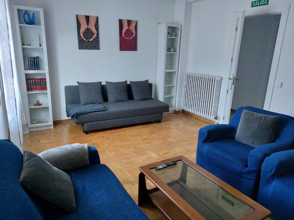 Sala de estar con 2 sofás azules y mesa de centro en Casa Korrontxas & Ega Txokoa, en Murieta