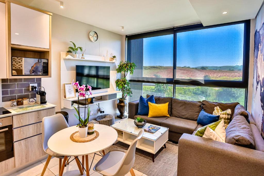 uma sala de estar com um sofá e uma mesa em Zimbali Lakes Boulevard Suites 103 em Ballito