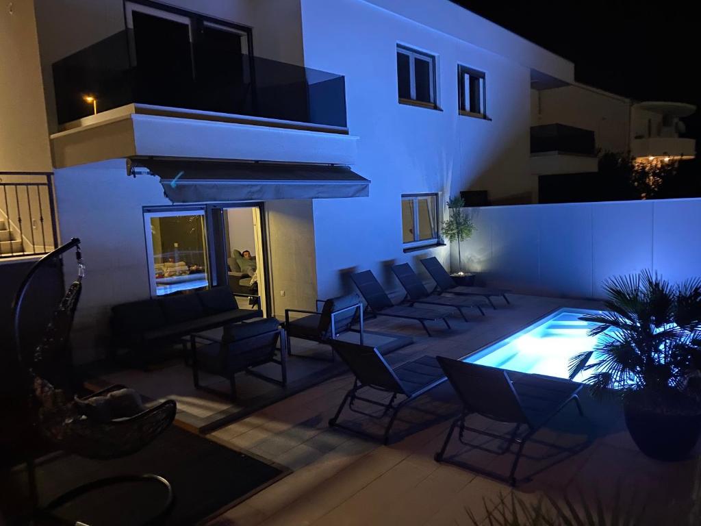 un soggiorno con piscina, sedie e un edificio di Holiday Home Miriam Kastela with a private pool a Kaštela (Castelli)