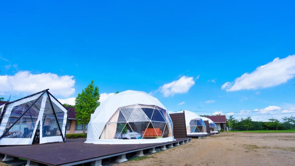 two geodesic domes on a deck with a blue sky at glampark Serakoyu Land in Sera