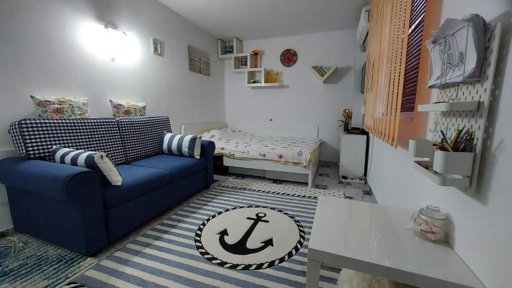 a living room with a blue couch and a table at Studio Olimp Black Sea in Olimp