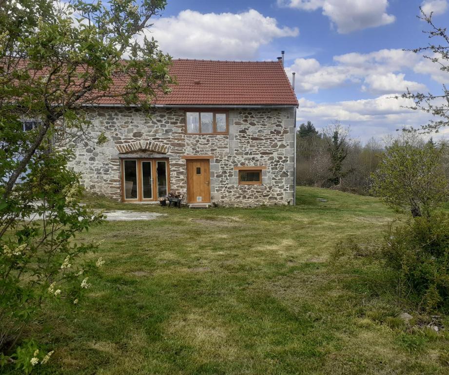 a stone house with a red roof at La Vieille Maison aux Canards in Neuvic-Entier