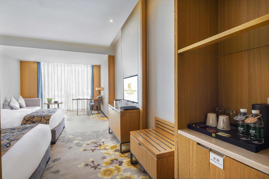 um quarto de hotel com duas camas e uma televisão em United Kingson HoteL em Chengdu