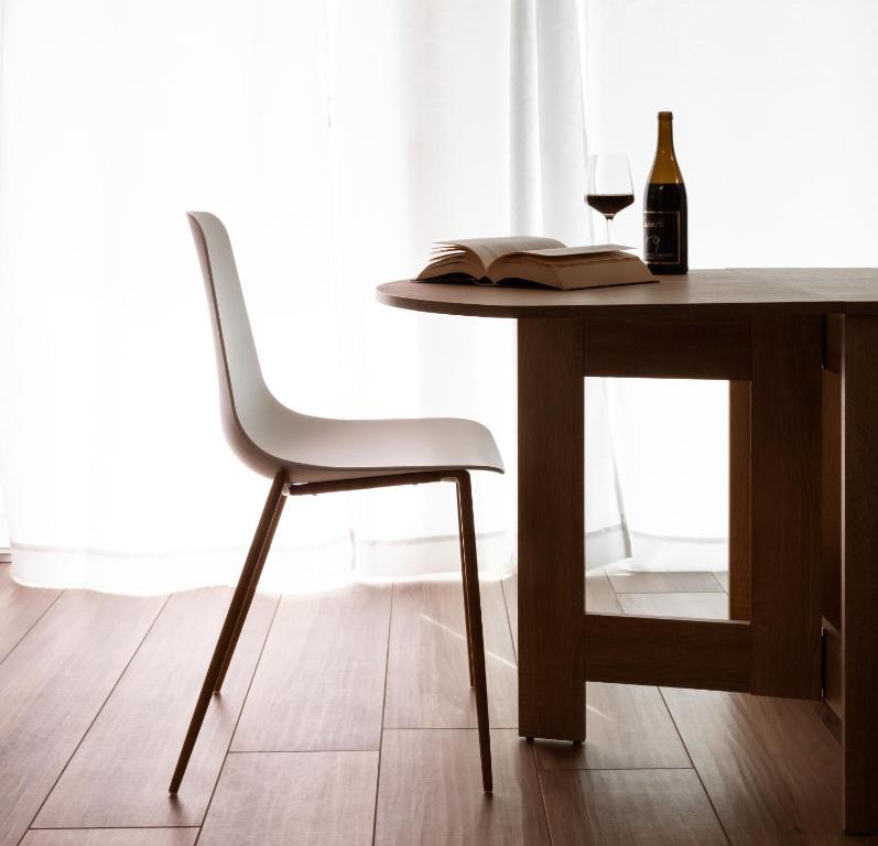 a table with a bottle of wine and a wine glass at Appartamenti Del Borgo in Borgosesia