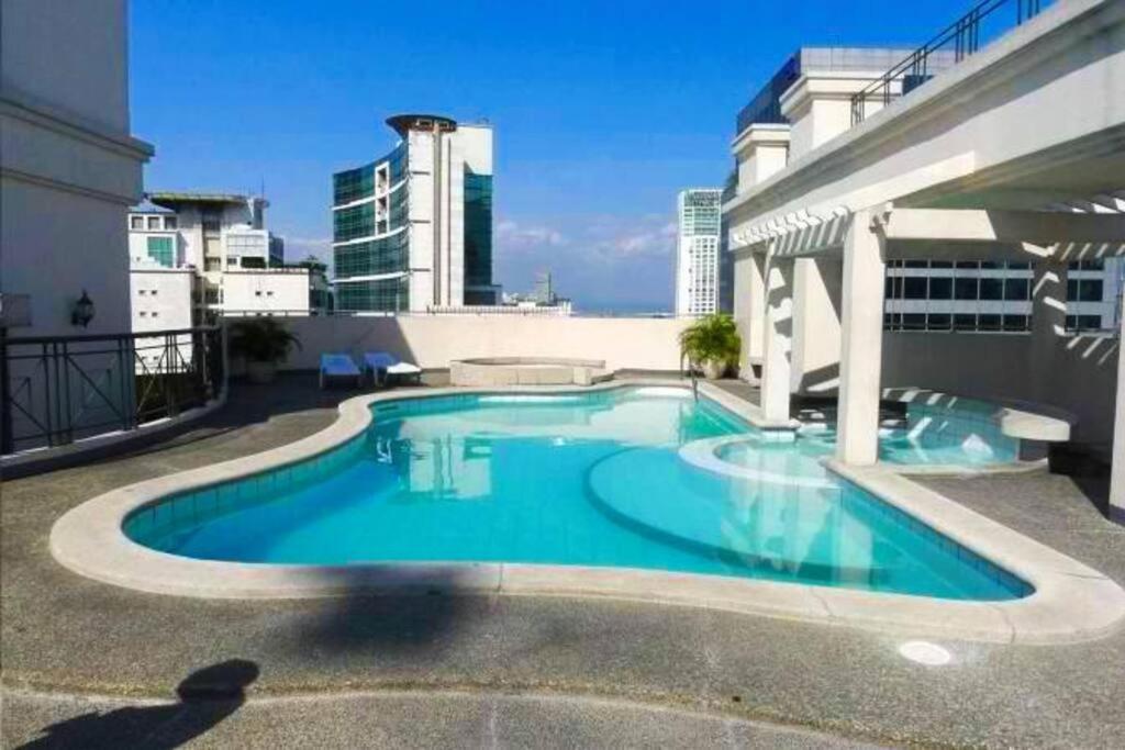 a swimming pool on the roof of a building at Makati Huge & Cozy Home w/Carpark in CBD; FibrWifi in Manila