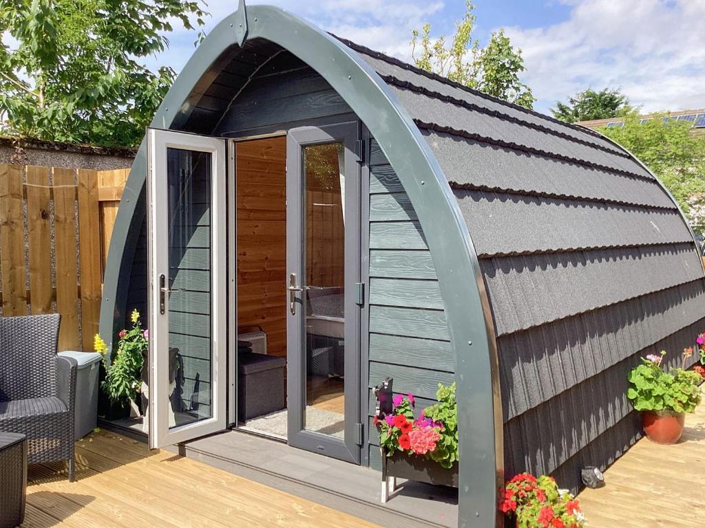 a gazebo with a door on a deck at The Dalmore Pod in Alness