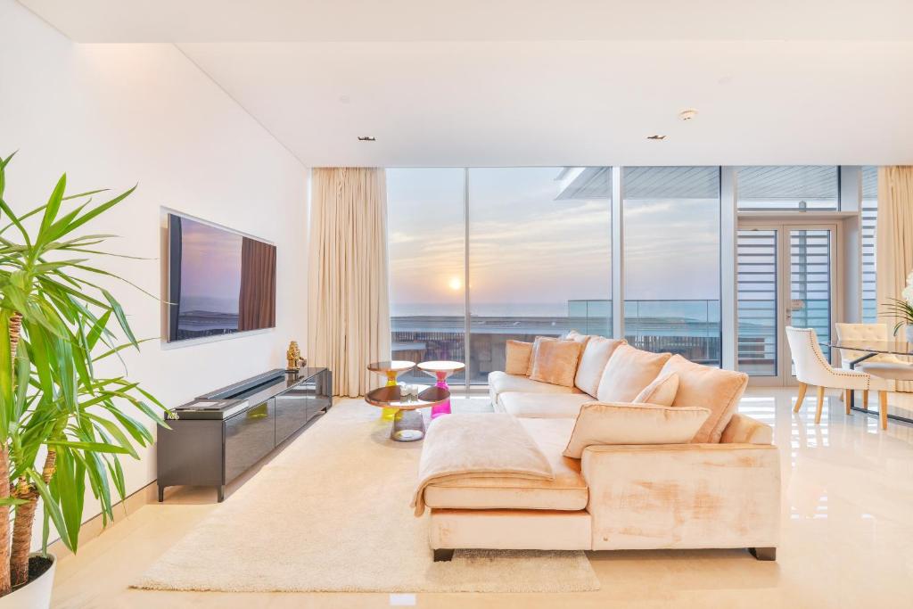 Una sala de estar con un sofá y un televisor. en Posh 2 BR Oceanfront Apt in the Heart of Bluewaters Island, en Dubái
