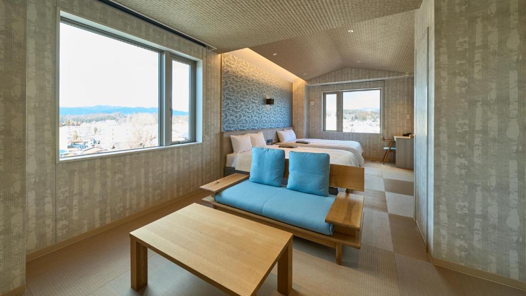 高山市にあるHotel and Spa Gift TAKAYAMAのホテルルーム(ベッド1台、青いソファ付)