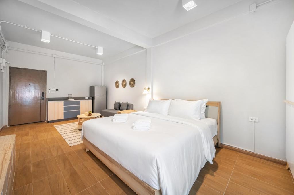 バンコクにあるHotel Wizpark Ratchadaの大きな白いベッドとキッチンのある寝室