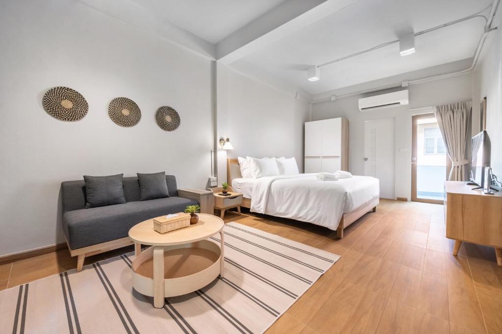 a living room with a bed and a couch at Hotel Wizpark Ratchada in Bangkok