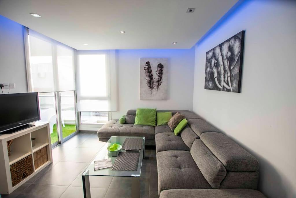 a living room with a couch and a flat screen tv at Glabur Stays - The Amazing 1 BDR - Executive apt Nicosia Center Free Parking & WiFi in Nicosia