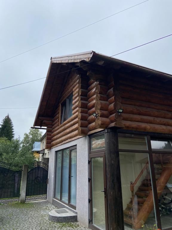 Casa de madera con porche y ventanas en Приватна садиба GREEN HOUSE en Mizhhirʼʼya