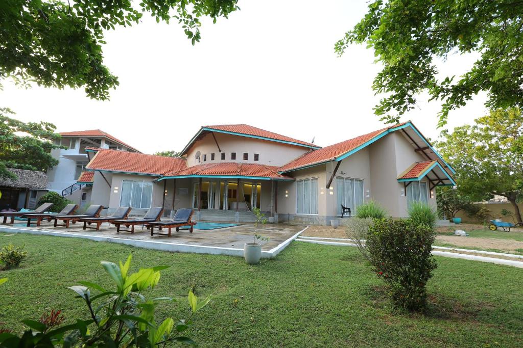 a house with a patio and a yard at The Beach house by Kay Jay Hotels in Pasikuda