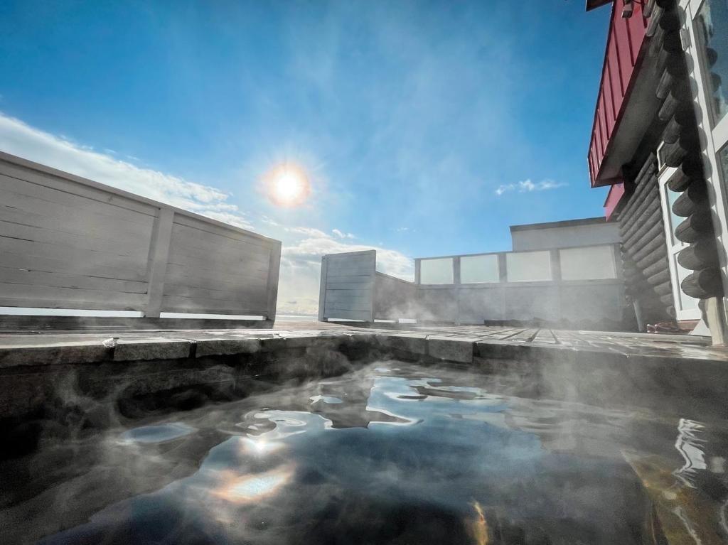 a hot pool of water next to a building at Oceanview 貸別荘Hosuikan in Shiraoi
