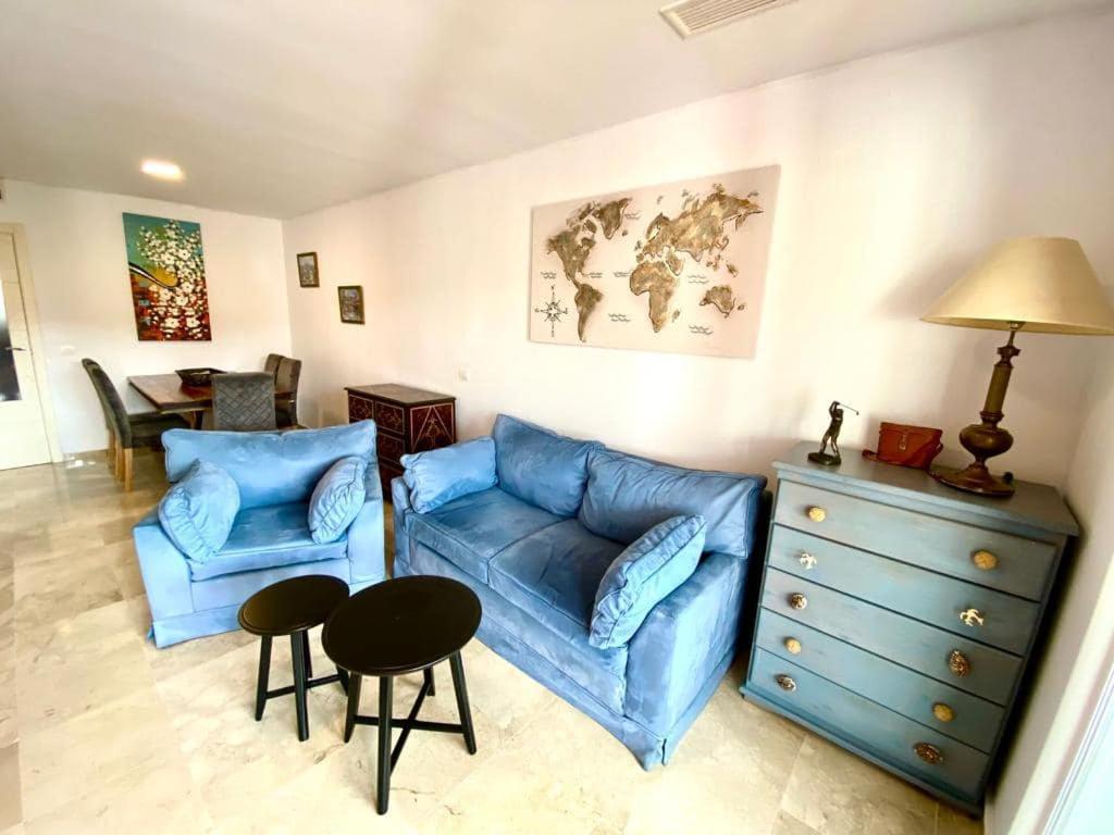 sala de estar con sofá azul y mesa en Apartment Alcaidesa, en Alcaidesa