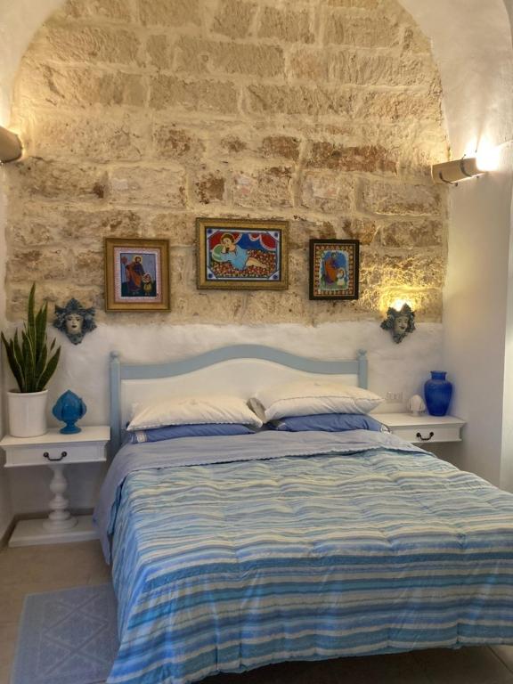 ein Schlafzimmer mit einem Bett und einer Steinmauer in der Unterkunft Casa Bandini in Galatone
