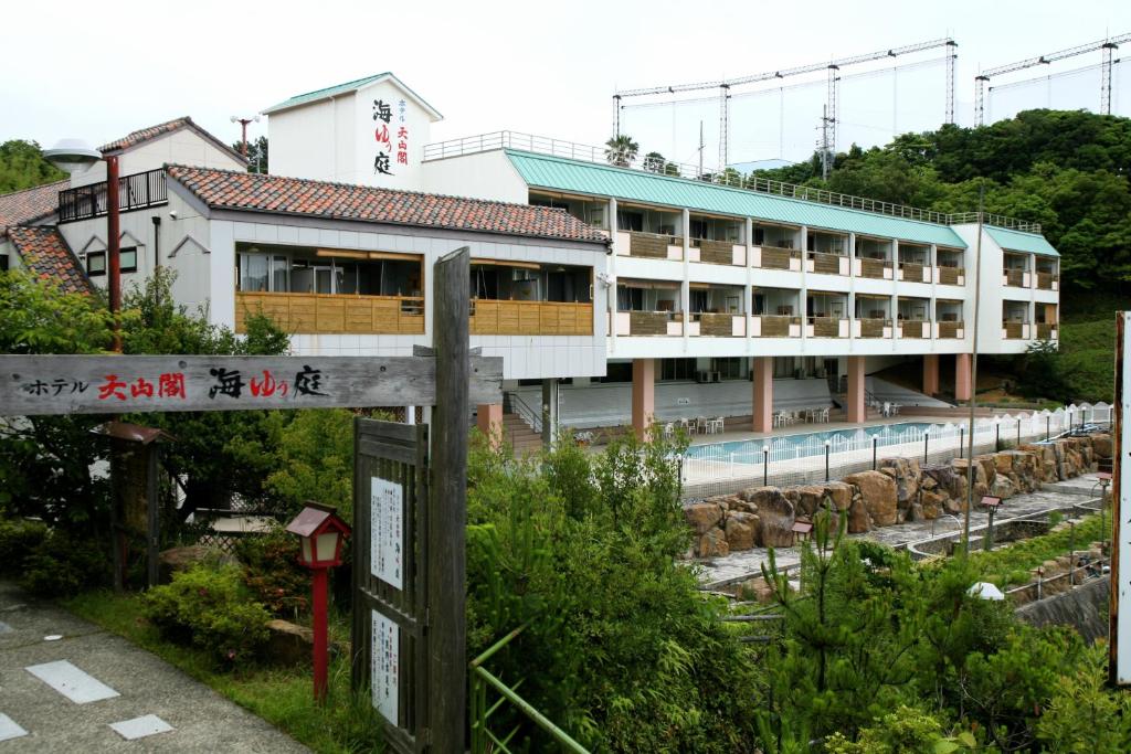 um edifício com um sinal em frente em Hotel Tenzankaku Kaiyutei em Shirahama