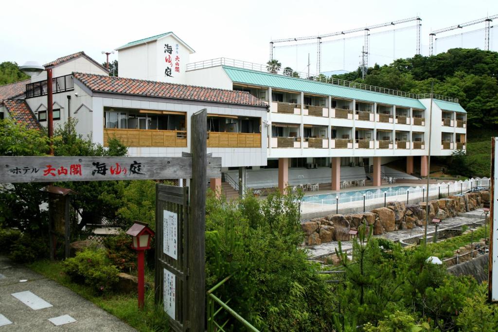 a building with a sign in front of it at Hotel Tenzankaku Kaiyutei in Shirahama