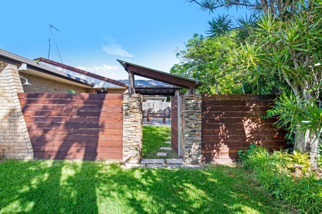 a brick retaining wall with a wooden pergola at Palm Beach Haven in Gold Coast