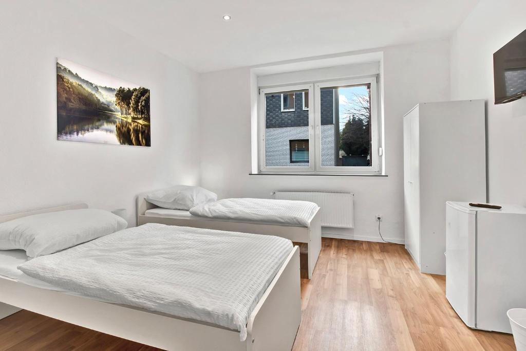 twee bedden in een kamer met twee ramen bij 3-room apartment in Bochum