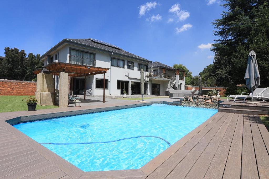 a large swimming pool in front of a house at Villa Portia in Johannesburg