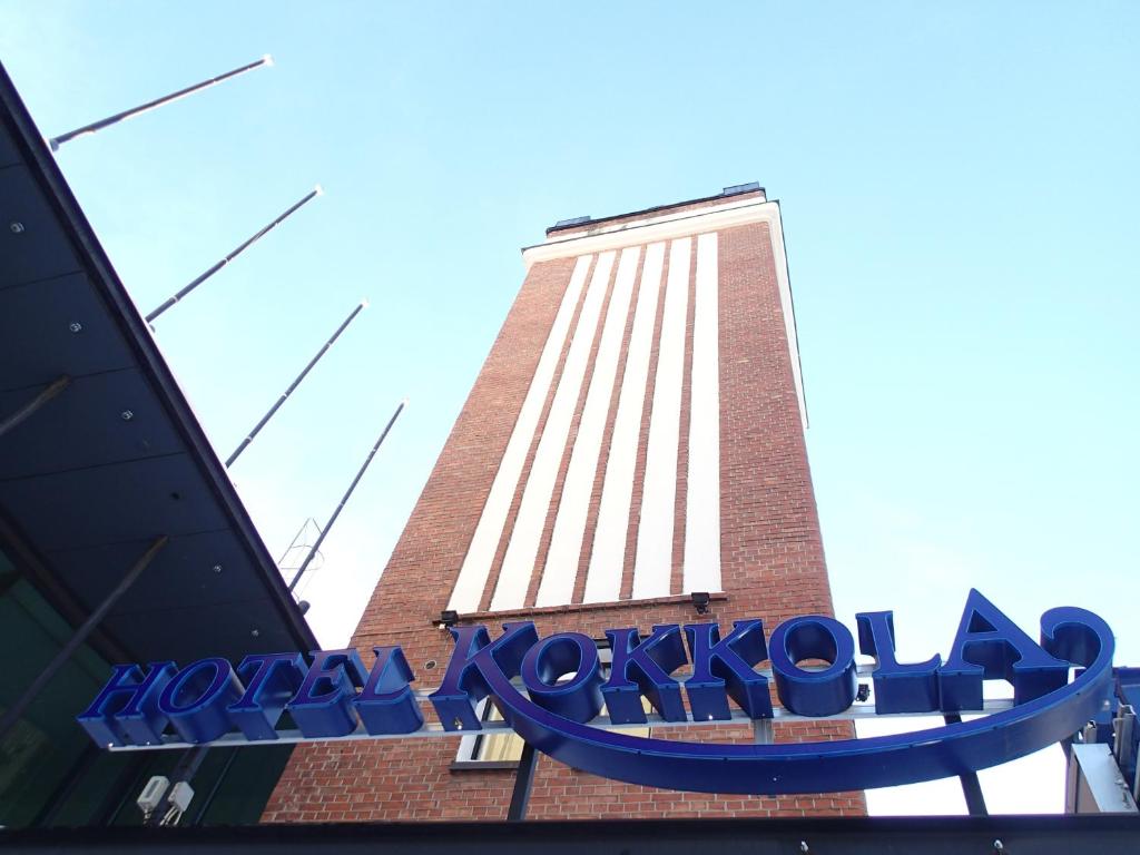 un cartello di fronte a un edificio con una torre dell'orologio di Hotel Kokkola a Kokkola