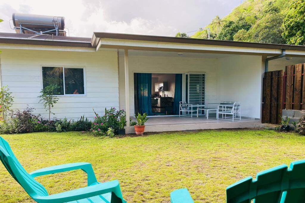 a house with a yard with chairs and a patio at Ana iti Lodge PAEA Tahiti in Paea