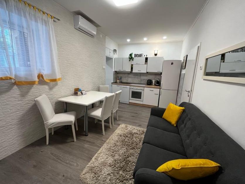 a living room with a couch and a table and a kitchen at Apartman Plasse in Rijeka