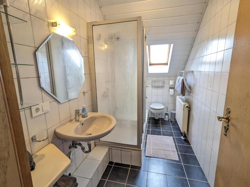 a bathroom with a sink and a shower and a toilet at Ferienwohnung Madenburgblick in Eschbach